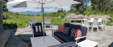 Patio looking northwest towards Camden Hills with kitchen/grill/fireplace.