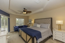 Primary bedroom features king bed, sitting area and desk.