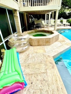 Beautiful marble travertine wraps itself around the private pool and hot tub